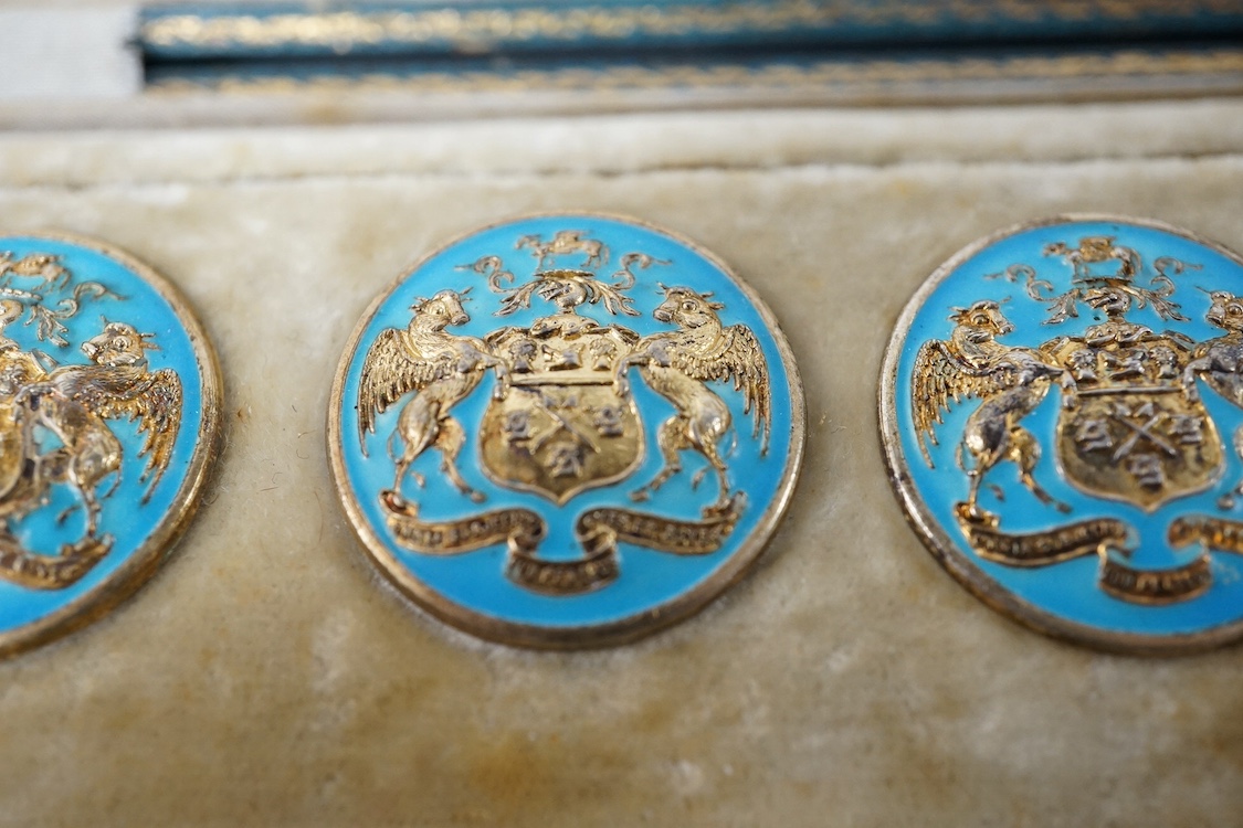 A George V set of 6 blue enamelled silver gilt buttons with armorial and motto 'omnia subjecisti subpedibus oves et boves', Elkington and Co, Crown Jewellers, Chester 1904, in original case inscribed 'With The Compliment
